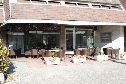 a patio with chairs and tables in front of a building at Hostel Paradiso in Tolmin
