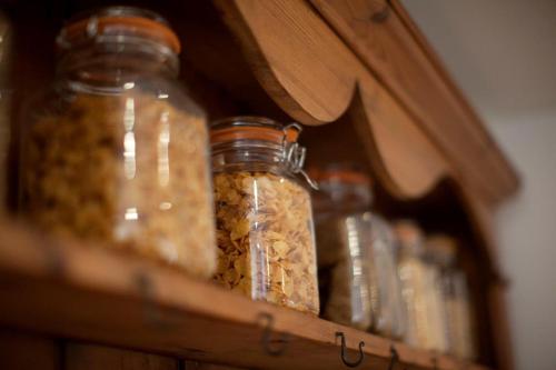 a group of glass jars filled with nuts on a shelf at Ye Olde Saddlery B&B in Neatishead
