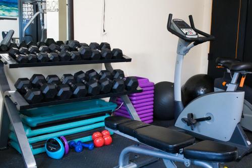 a gym with a bench and dumbbells and a exercise equipment at Villa Cofresi in Rincon