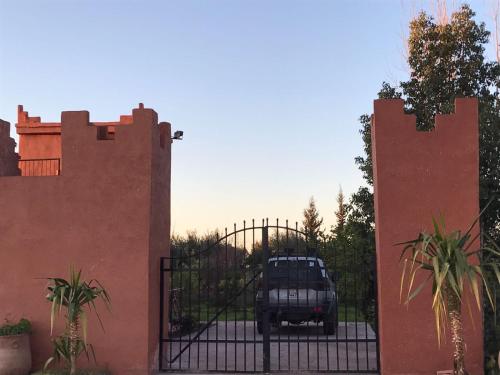 a truck parked behind a gate in a driveway at Chez Kossai Atlas Farm in Chtawna