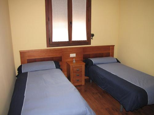 una camera con due letti, uno specchio e una finestra di Benages-Chiva a Puertomingalvo
