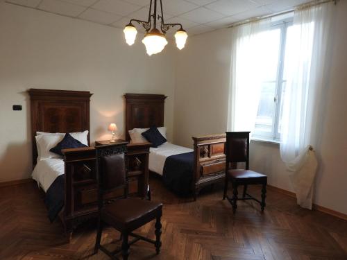 a bedroom with two beds and a table and chairs at B & B Abbadia in Monesiglio