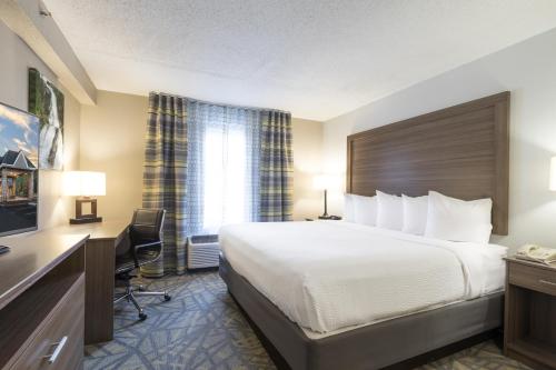 a hotel room with a large bed and a desk at Country Inn & Suites by Radisson Asheville Downtown Tunnel Road in Asheville