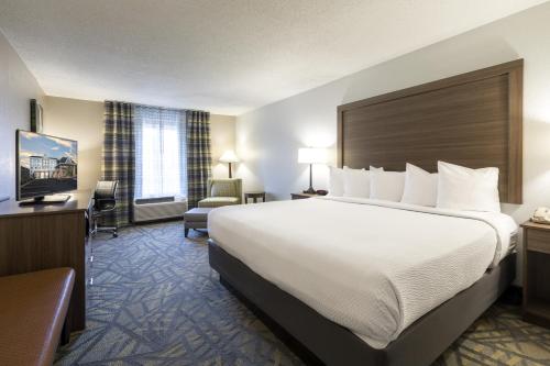 a hotel room with a large bed and a chair at Country Inn & Suites by Radisson Asheville Downtown Tunnel Road in Asheville
