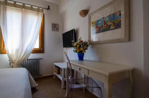 a room with a desk with a vase of flowers on it at CelesteDiMare in Palau