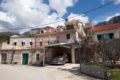 a car parked in a garage in front of a house at Old stone house Mario in Podgora