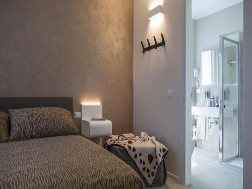 a small bedroom with a bed and a bathroom at Hotel Buena Onda in Peschiera del Garda