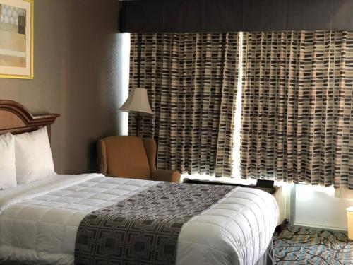 a hotel room with a bed and a window at Baymont by Wyndham Walterboro in Walterboro
