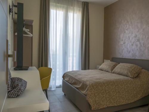 a bedroom with a bed and a window at Hotel Buena Onda in Peschiera del Garda