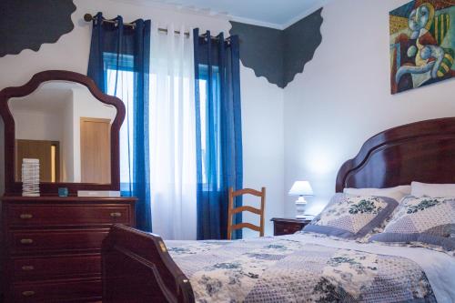 Schlafzimmer mit einem Bett, einer Kommode und einem Spiegel in der Unterkunft Apartamento Sandra in Ponta Delgada