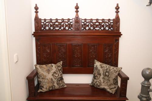 a wooden bench with two pillows against a wall at Guest house Villa Fritz in Potsdam