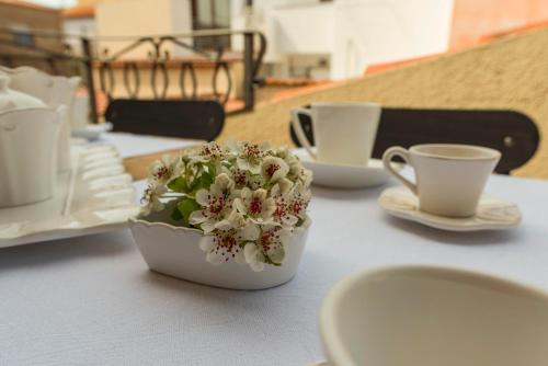 a white bowl with flowers on a table with cups at CelesteDiMare in Palau