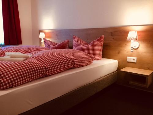 a bedroom with a bed with red and white pillows at Braugasthof Trompete in Eichstätt
