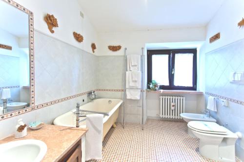 a bathroom with a tub and a toilet and a sink at Villa Osperellone in Perugia