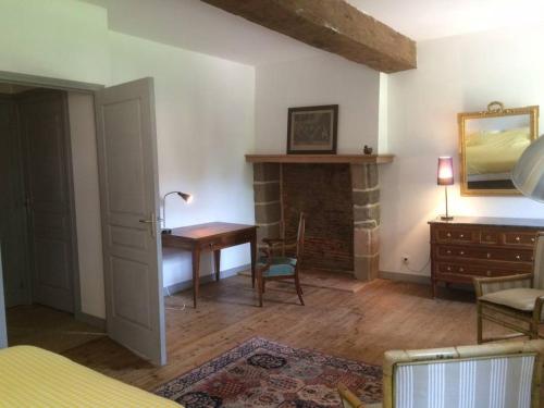 Cette chambre dispose d'une cheminée, d'une table et d'un bureau. dans l'établissement Magnifique corps de ferme XVII ème, à Romille