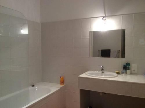 une salle de bain avec un lavabo, une baignoire et un miroir dans l'établissement Magnifique corps de ferme XVII ème, à Romille