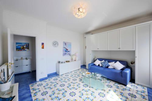 un soggiorno con divano blu e tavolo di Chez Amélie ad Amalfi