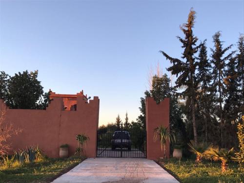 a gate to a house with a car behind it at Chez Kossai Atlas Farm in Chtawna