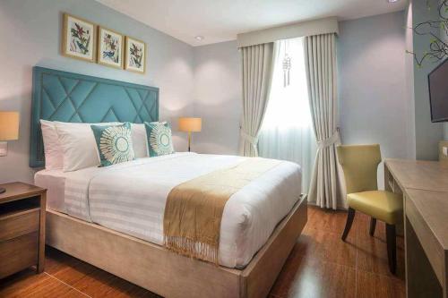 a bedroom with a bed and a desk and a window at Dalian Peak Hotel in Angeles