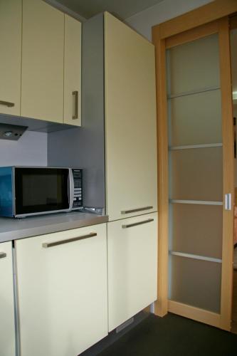 a kitchen with white cabinets and a microwave at Luxury apartment in the heart of the capital in Kyiv