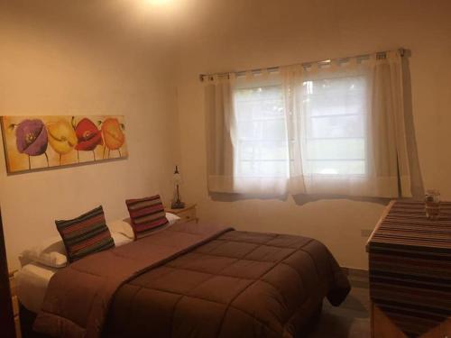 a bedroom with a bed and a window at Altos de Obligado in Vuelta de Obligado