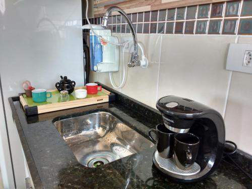 - un évier de cuisine avec une cafetière dans l'établissement Amor e aconchego beira mar e ar condicionado, à Praia Grande