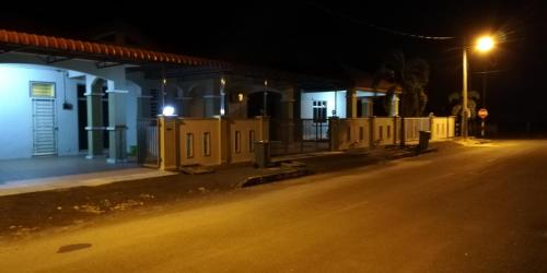uma rua vazia à noite com uma fila de casas em Hazim Homestay Changlun Pakej Esklusif em Changlun