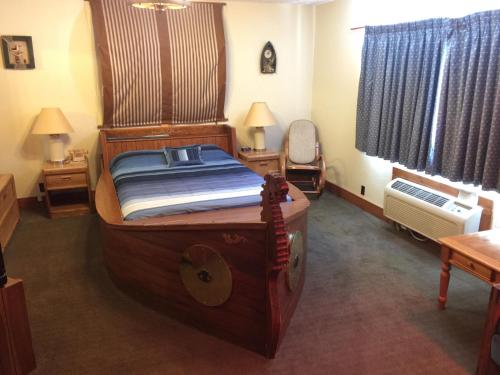 a bedroom with a large wooden bed in a room at Don Q Inn in Dodgeville