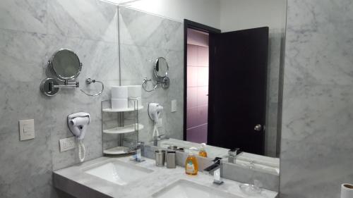 baño con 2 lavabos y espejo grande en Exclusive Apartment, en Lima