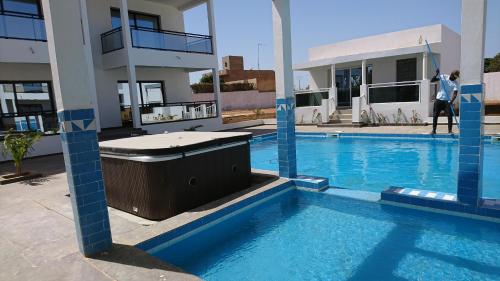 a large swimming pool in front of a building at Le Ngapatel Bungalow Thaï in Ngaparou