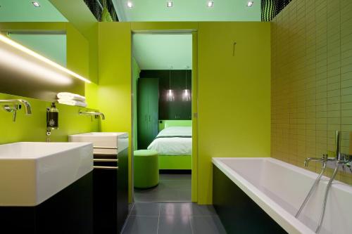 a bathroom with a sink and a tub and a bed at Hôtel Montmorency & Spa in Carcassonne