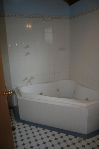 a bath tub in a bathroom with a tiled floor at Molly's Chase in Clare