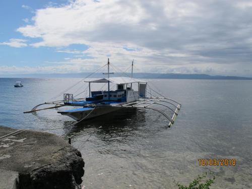 a boat is docked in the middle of the water at Cabilao Sunset Dive & Beach Resort in Loon