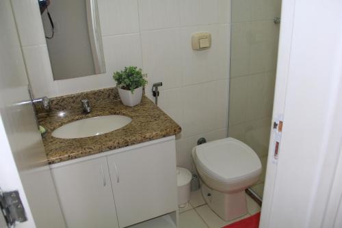La salle de bains est pourvue d'un lavabo et de toilettes. dans l'établissement Relax.guarapari, à Guarapari