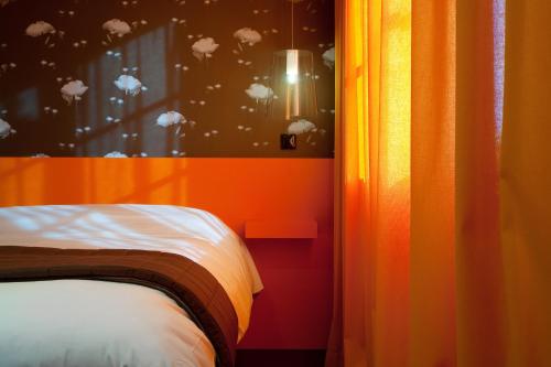 a bedroom with a bed and a window with clouds at Hôtel Montmorency & Spa in Carcassonne