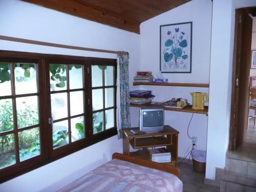 a bedroom with a bed and a desk with a television at Le Pit in Lessac