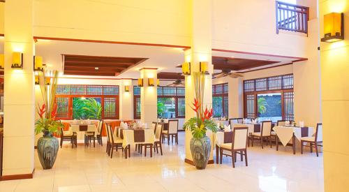 a restaurant with tables and chairs in a building at Le Murraya Boutique Serviced Residence & Resort in Chaweng