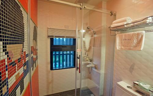 a shower with a glass door in a bathroom at Mori Inn in Beipu