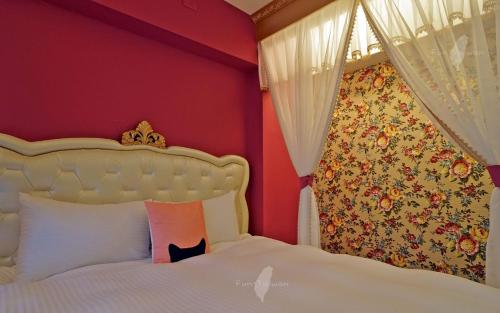 a bedroom with a white bed with a red wall at Mori Inn in Beipu