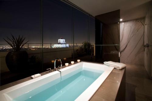 a bathroom with a bath tub with a view of the city at Andaz West Hollywood, By Hyatt in Los Angeles