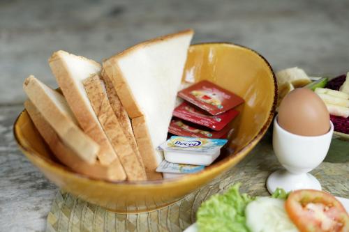 een kom eten met brood en eieren op een tafel bij Imagine Bali in Ubud
