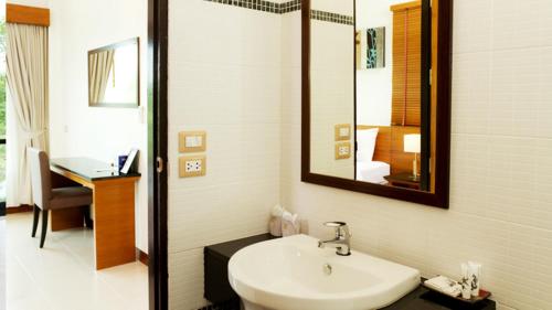 a bathroom with a sink and a mirror at Khaolak Blue Lagoon Resort - SHA Extra Plus in Khao Lak