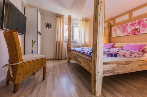 a bedroom with a wooden bed and a tv at Pension Kuhn in Rust