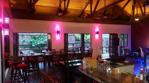 Infinity Sands Resort في سيكويجور: وجود بار بالطاولات والكراسي في المطعم