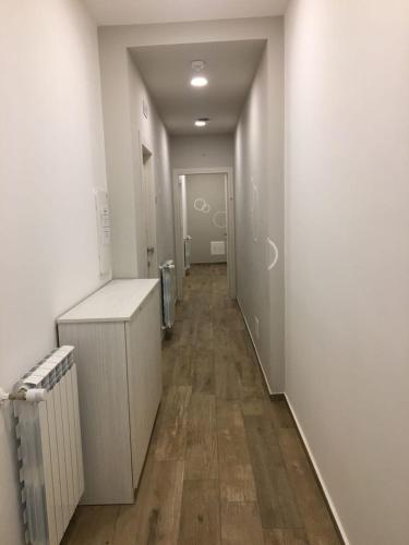 a hallway of a bathroom with white walls and wooden floors at Ai Gradini Affittacamere in Castellammare del Golfo