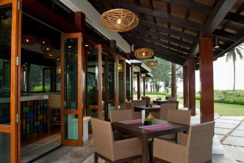 a restaurant with tables and chairs on a patio at Khaolak Blue Lagoon Resort - SHA Extra Plus in Khao Lak