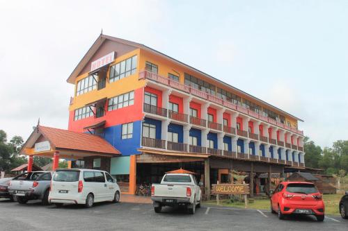 a building with cars parked in a parking lot at AM Transit Inn Kuala Terengganu in Kuala Terengganu