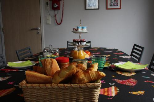 a table with a basket of bread on it at Le Verger B&B in Gorron