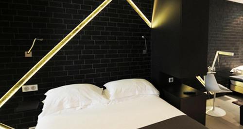 a bedroom with a white bed with a brick wall at Arc de Triomphe Etoile in Paris