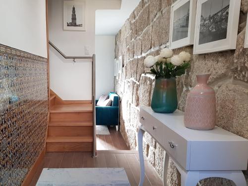 a room with a table with a vase on it at 22 Oporto Guesthouse in Porto